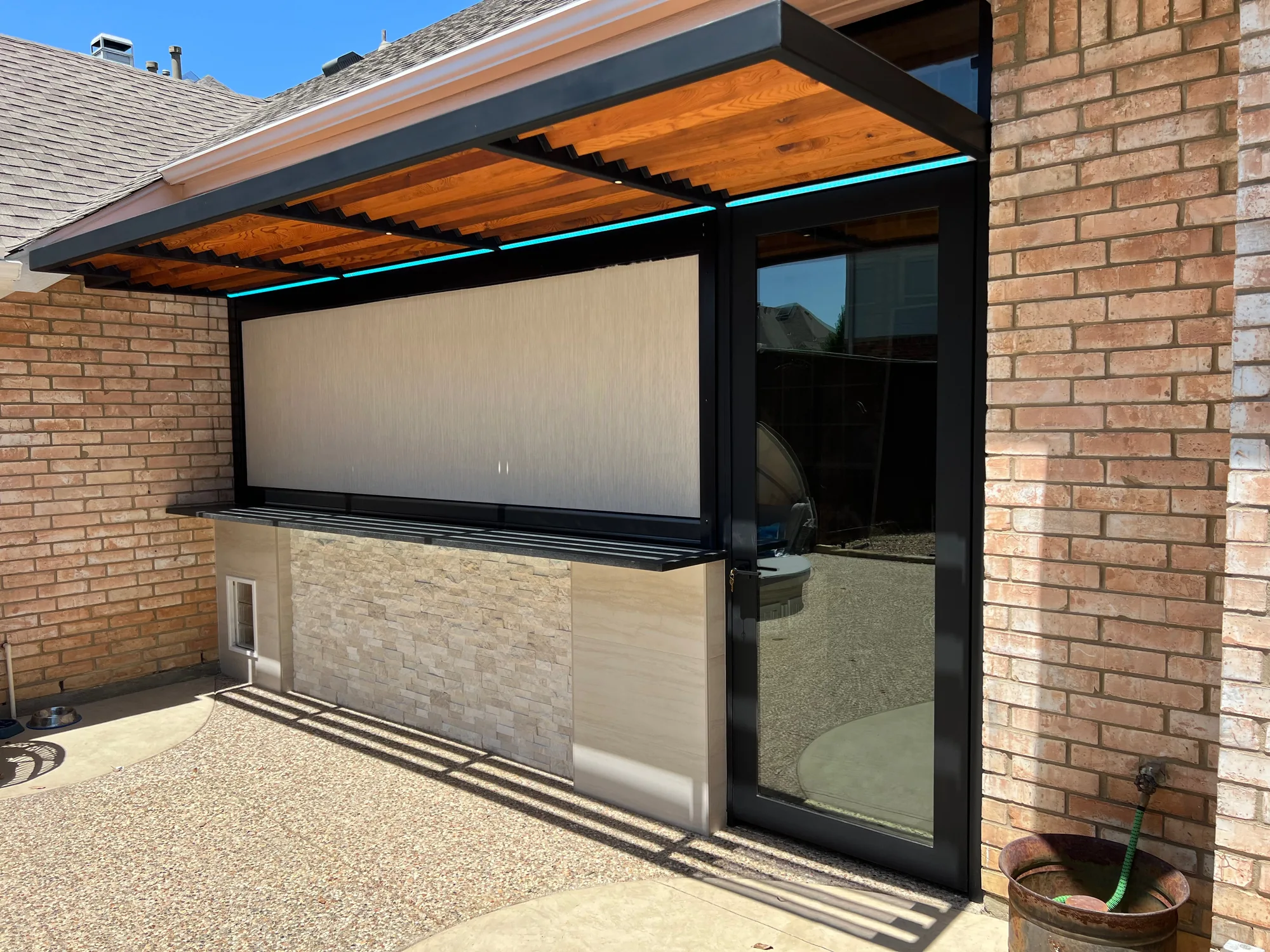 A gray garage door is sitting in front of a brick building.